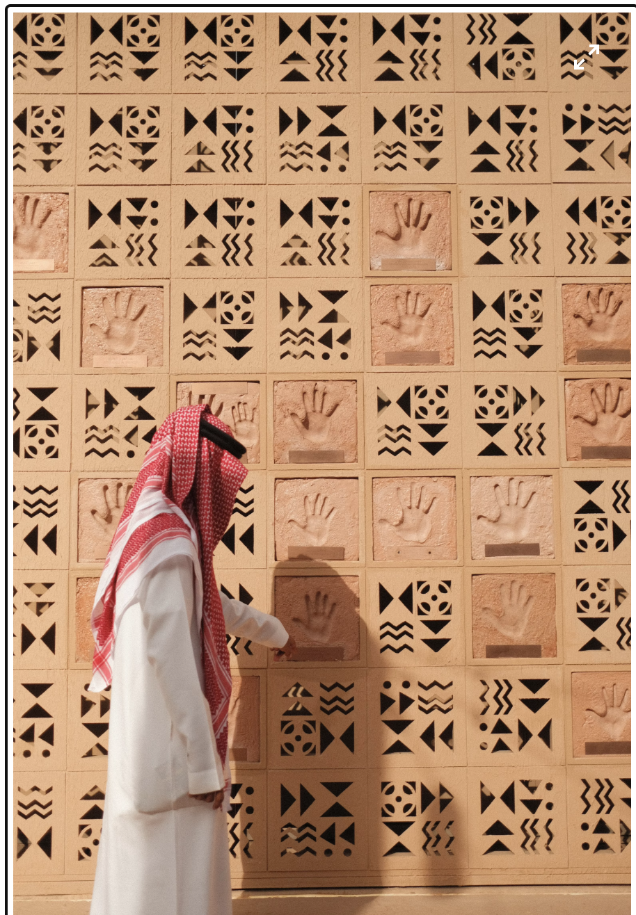 Traditional Saudi heritage wall with carved geometric patterns and handprints